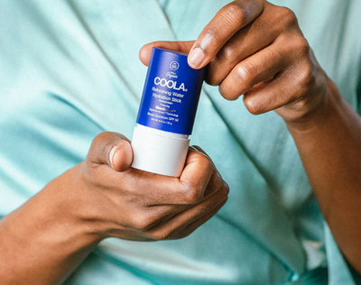 Person holding a Refreshing Water Hydration Stick organic face sunscreen SPF 50 for easy daily hydration and protection.