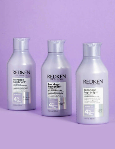 Redken Blondage High Bright Conditioner bottles for vibrant blonde hair care on a lavender background.