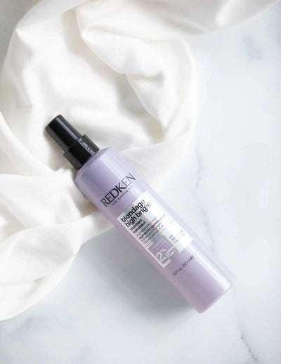 Redken Blondage High Bright Treatment spray for blonde hair on a soft white background. Ideal for enhancing brightness and reducing brassiness.