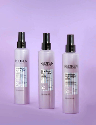 Redken Blondage High Bright Treatment bottles on a pastel purple background, ideal for enhancing blonde hair vibrancy.