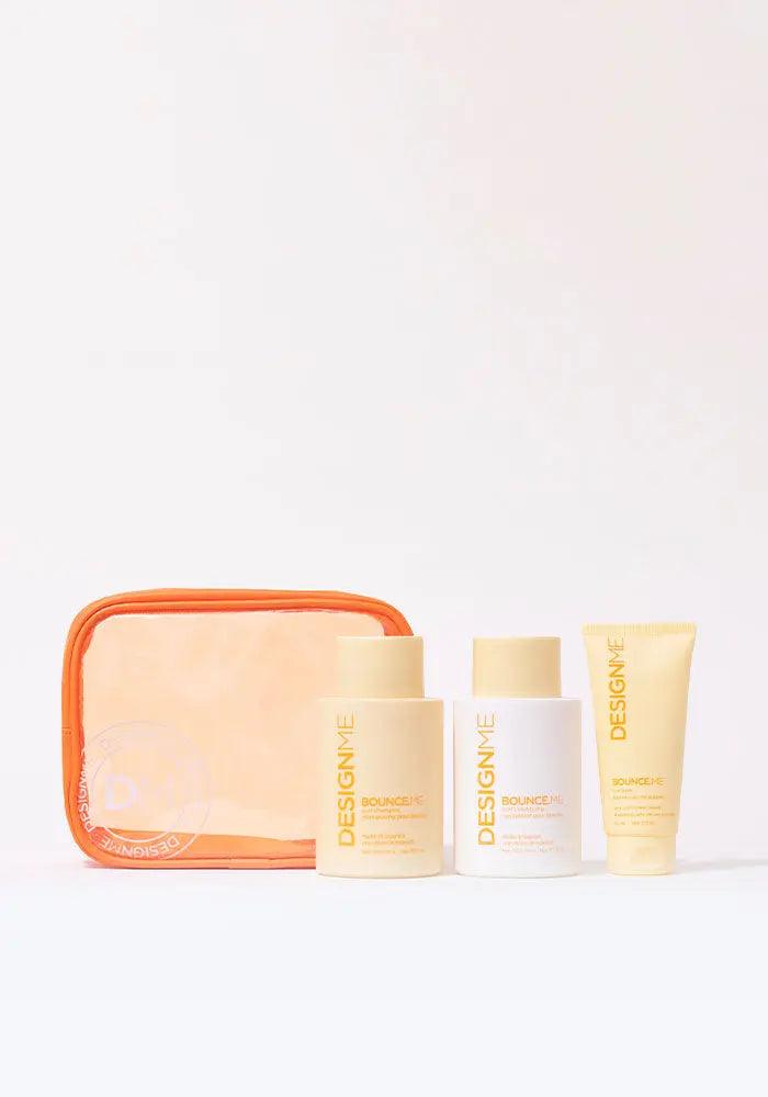 BOUNCE.ME Curl Glitz Kit featuring curl shampoo, conditioner, and balm in an orange pouch for defined, bouncy curls.