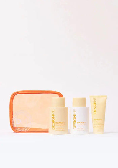 BOUNCE.ME Curl Glitz Kit featuring curl shampoo, conditioner, and balm in an orange pouch for defined, bouncy curls.
