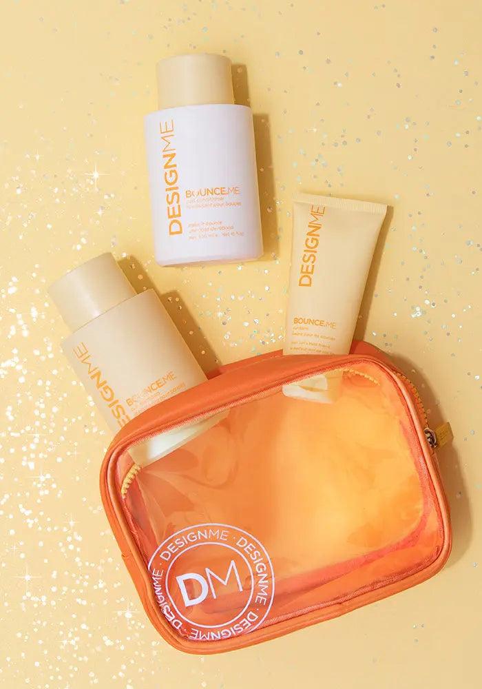 BOUNCE.ME Curl Glitz Kit featuring shampoo, conditioner, curl balm, and an orange pouch on a glittering yellow background.