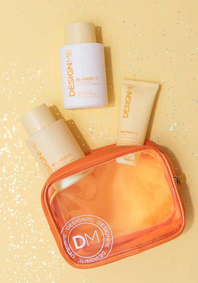 BOUNCE.ME Curl Glitz Kit featuring shampoo, conditioner, curl balm, and an orange pouch on a glittering yellow background.