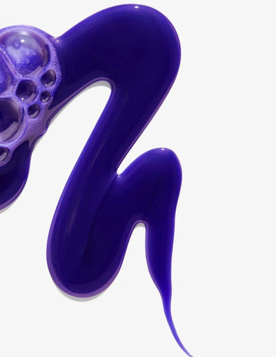 Purple color-depositing shampoo texture with bubbles, ideal for enhancing blonde and highlighted hair.