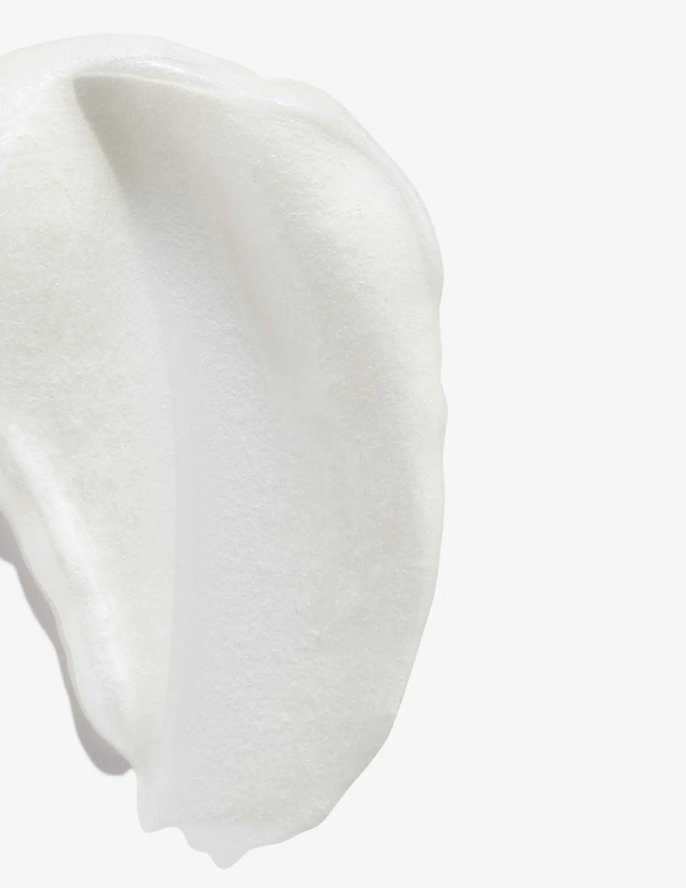 Close-up of a creamy, white texture resembling the Redken Color Extend Magnetics Conditioner.