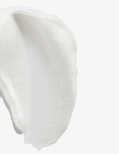 Close-up of a creamy, white texture resembling the Redken Color Extend Magnetics Conditioner.
