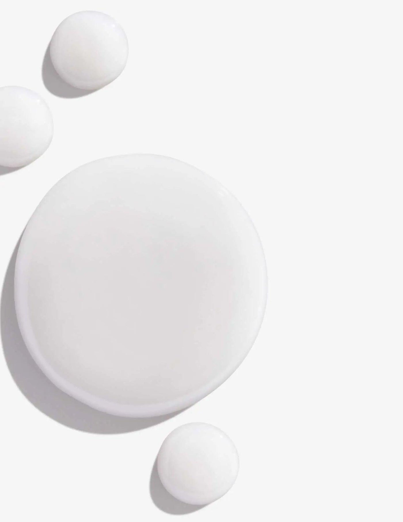 White cream or lotion in various circular shapes on a light background. Perfect for skincare and beauty product visuals.