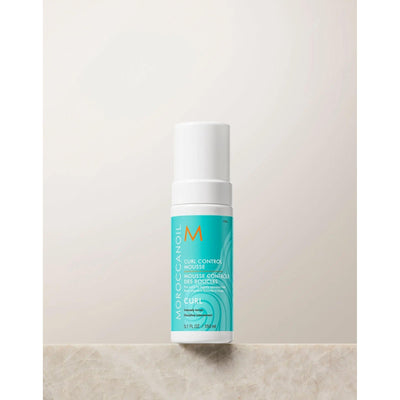 Moroccanoil Curl Control Mousse bottle on a neutral background, designed for defining and taming curly hair.