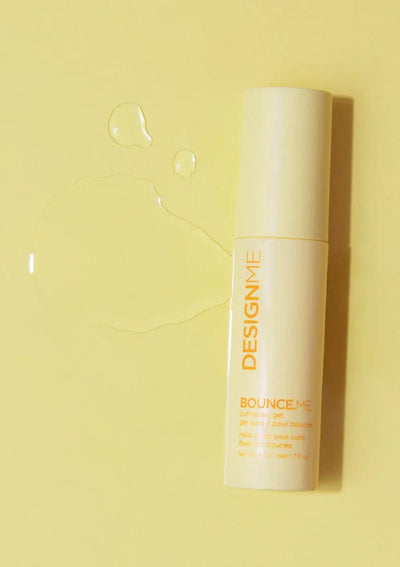 BOUNCE.ME curl spray gel bottle on a yellow background with water droplets, perfect for defined curls.
