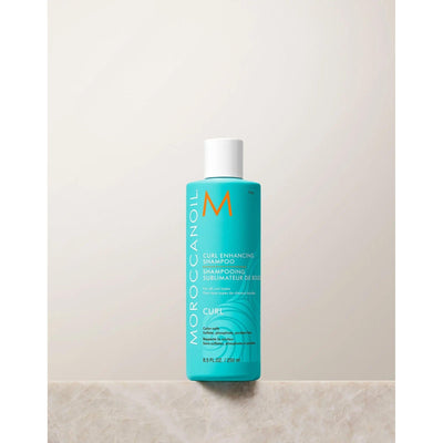 Moroccanoil Curl Enhancing Shampoo bottle on a neutral background, promoting soft, defined curls with nourishing ingredients.