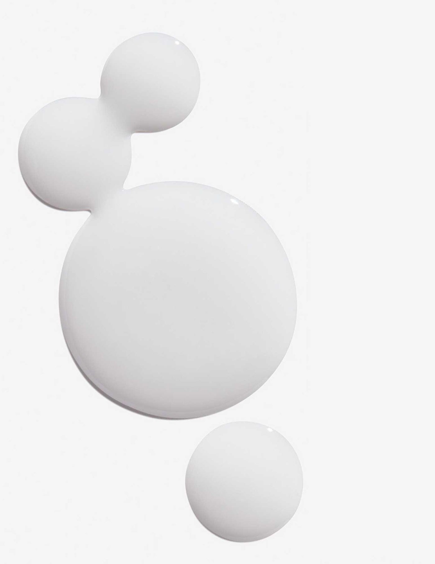 Three droplets of Redken Extreme Anti-Snap Treatment, showcasing the creamy texture ideal for damaged hair care.