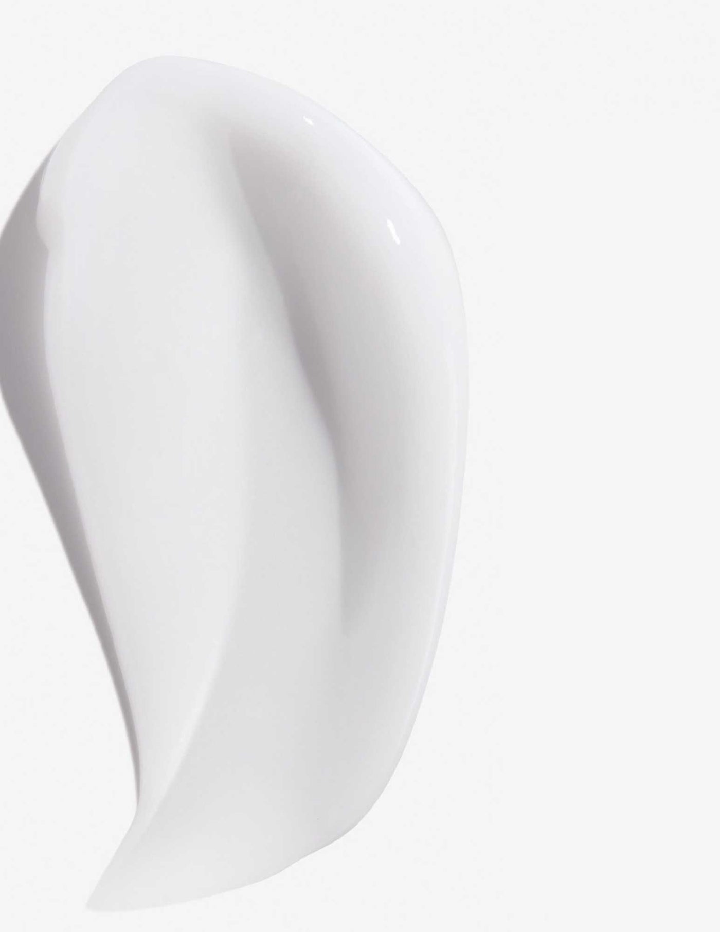 Smooth, white texture of Redken Frizz Dismiss Mask, designed for frizz-free, manageable hair.
