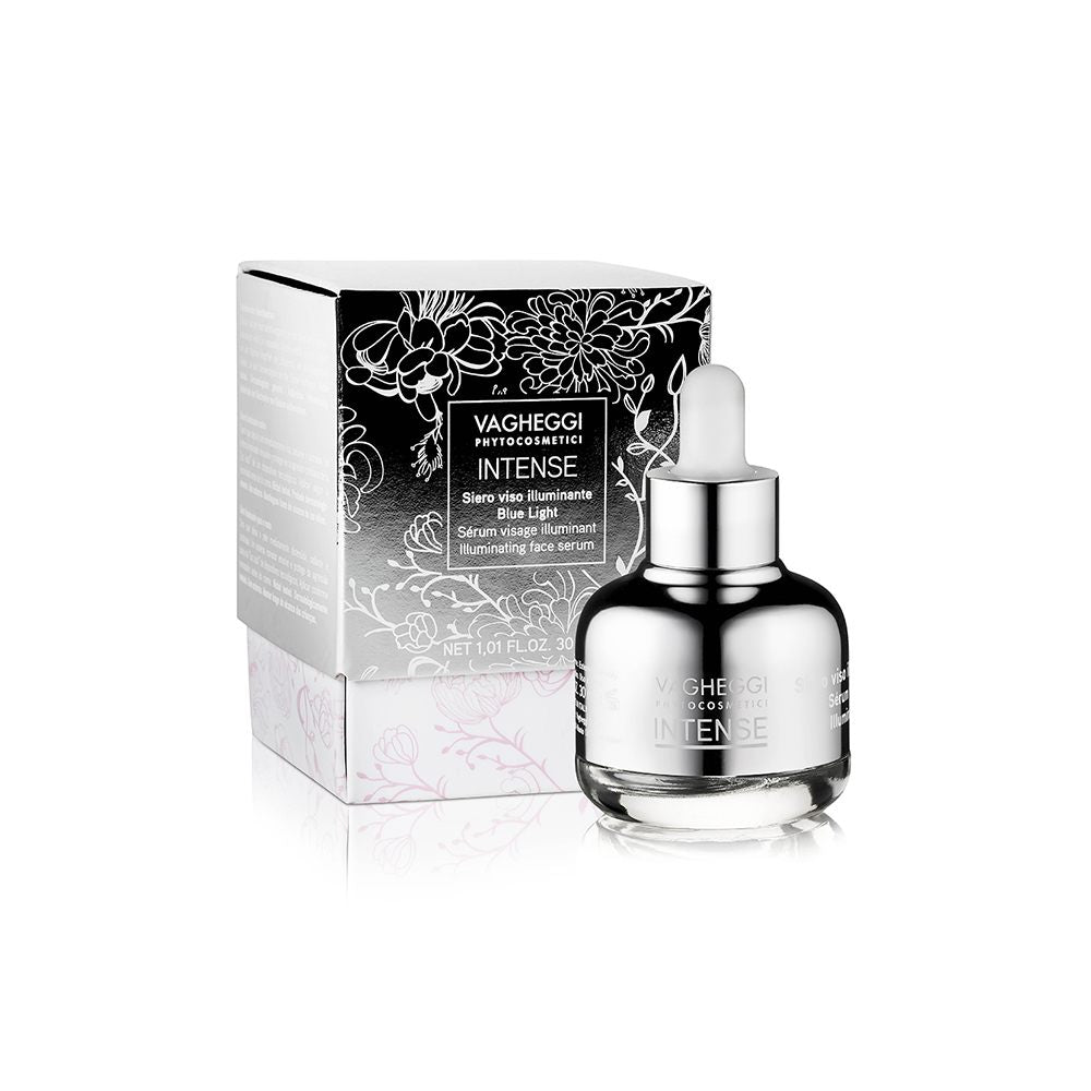Intense Illuminating Face Serum in sleek silver bottle with floral packaging, 30ml, protects skin from blue light and enhances radiance.
