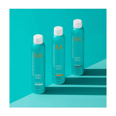 Three bottles of Moroccanoil® Luminous Medium Finish Hairspray against a turquoise background, showcasing hair styling products.