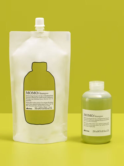 Momo Shampoo Refill pouch and bottle for nourishing dry hair with yellow melon extract, displayed on a green background.
