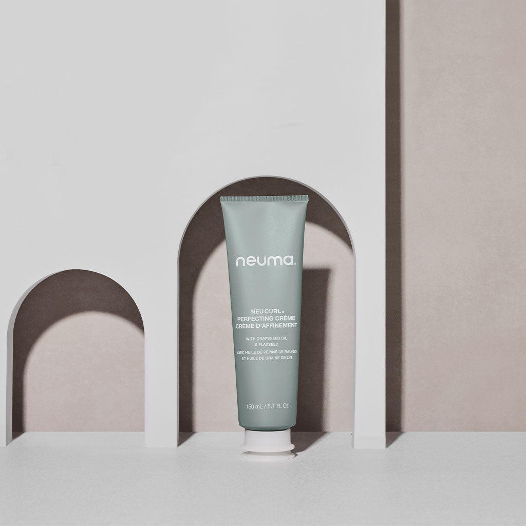 Neuma Neu Curl Perfecting Crème in a tube, enhancing curls with coconut hibiscus aroma for frizz-free waves.