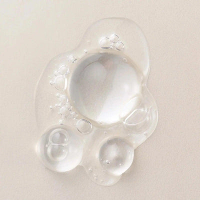 Clear, lightweight hair serum drops showcasing nourishing bubbles for hair protection and shine.