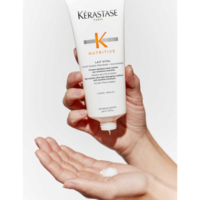Kérastase Nutritive Lait Vital Conditioner in a hand, showcasing its nourishing formula for fine to medium dry hair.