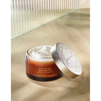 Moroccanoil body butter jar with creamy texture, designed for intense hydration and nourishment of dry skin.