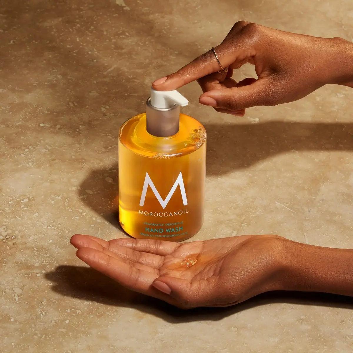 Hand washing with Moroccan Oil hand wash, featuring a bottle of gentle, hydrating formula infused with argan oil.