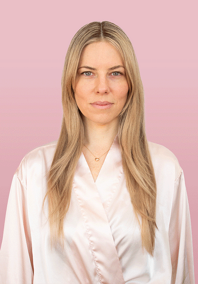 Model showcasing sleek, voluminous hair wearing a light satin robe against a soft pink background.