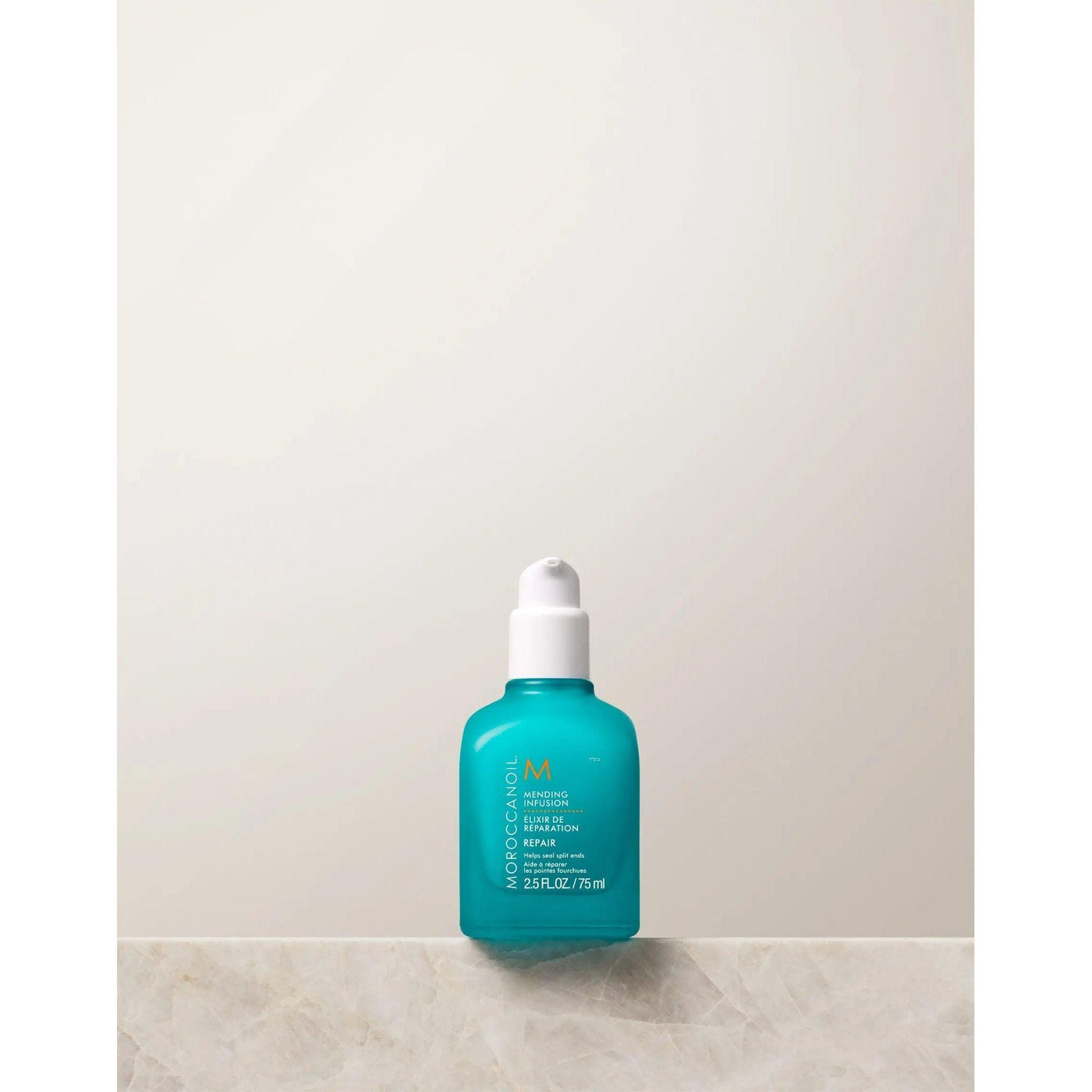 Moroccanoil's Mending Infusion styling product in a turquoise bottle on a light background.