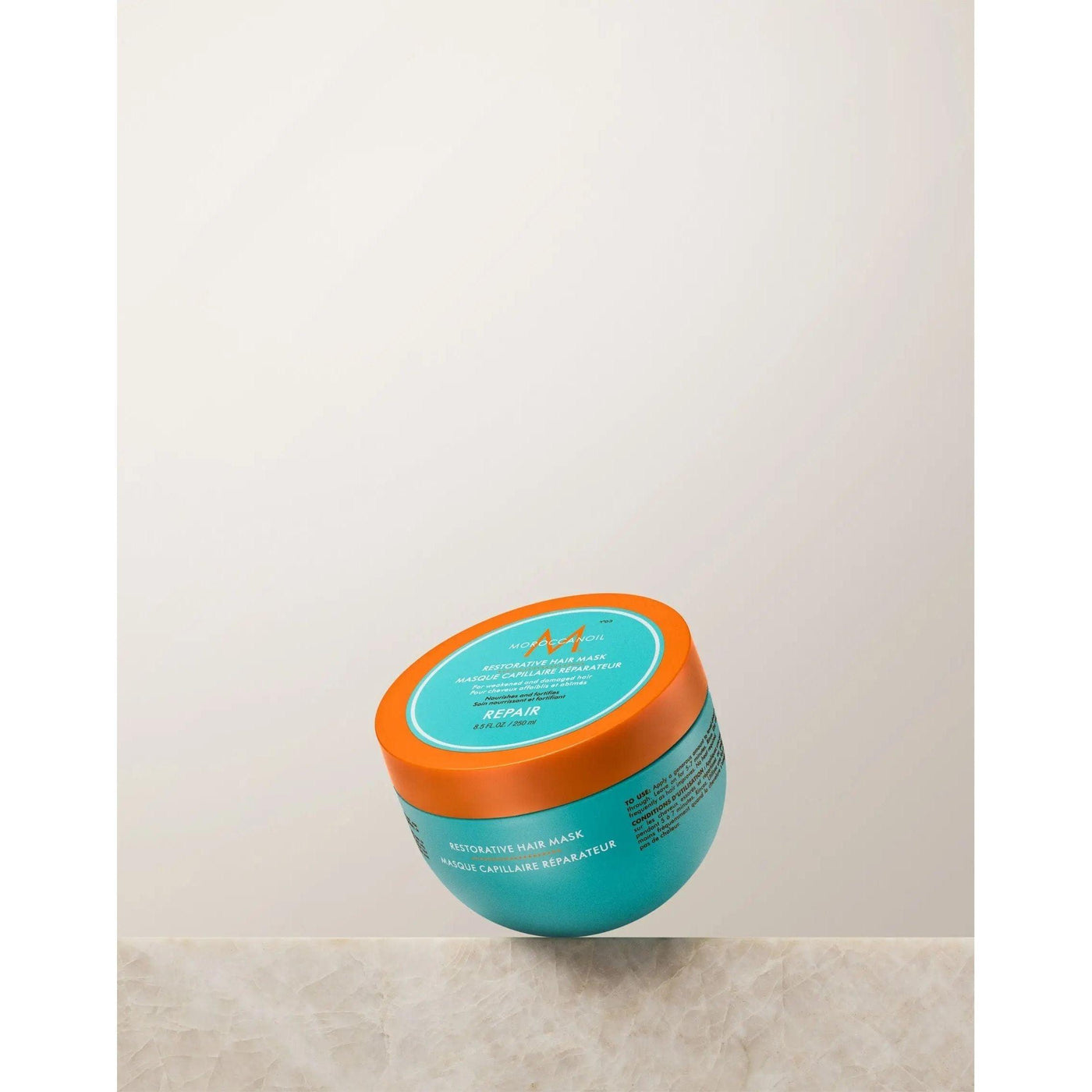 Restorative Repair Hair Mask in a turquoise jar with orange lid, designed for deep hair repair and hydration.