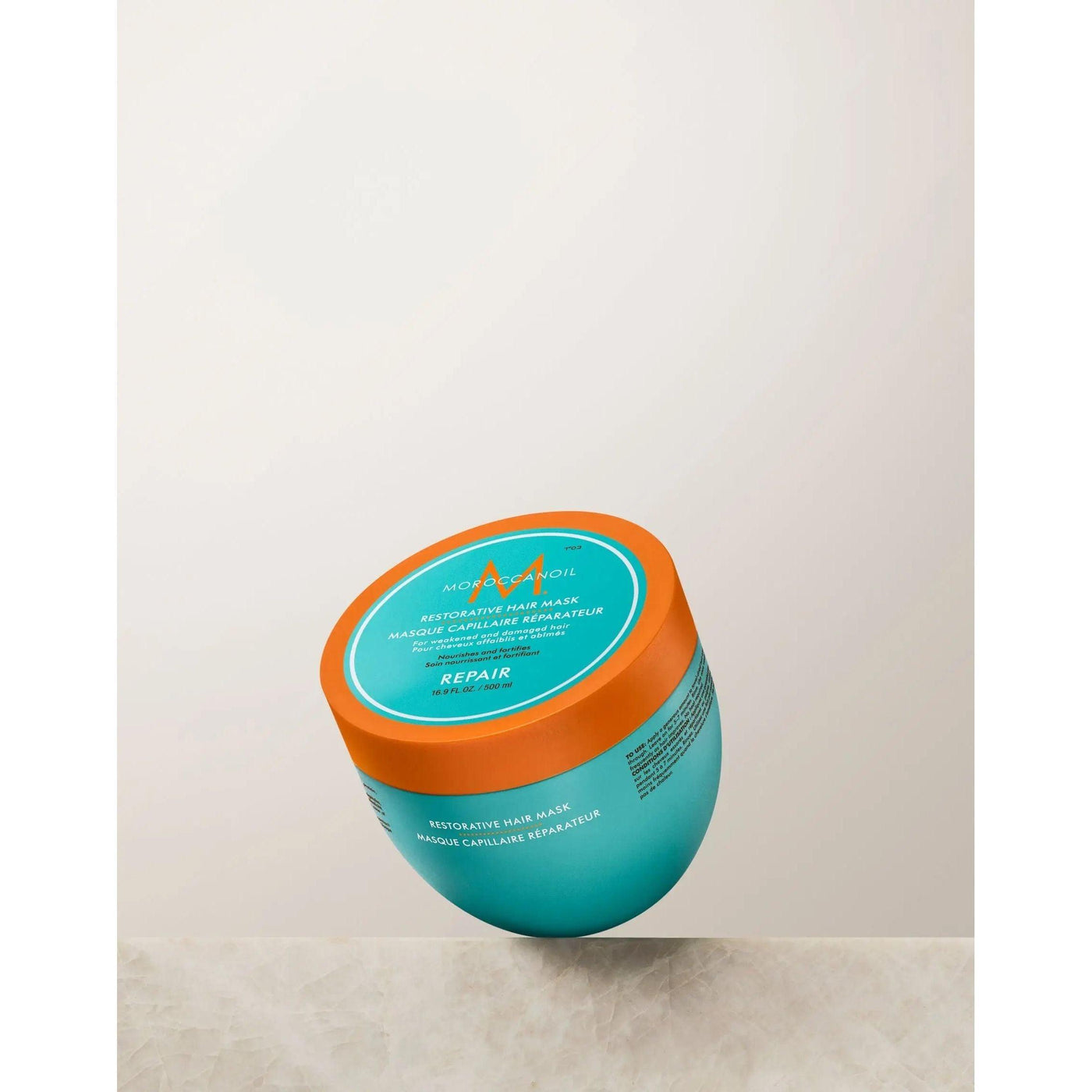 Restorative Repair Hair Mask in turquoise container with orange lid, ideal for repairing damaged and dry hair.