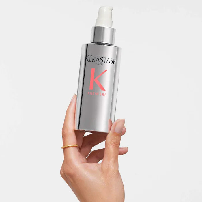 Kérastase Sérum Filler Fondamental for damaged hair in a silver pump bottle held in a hand.
