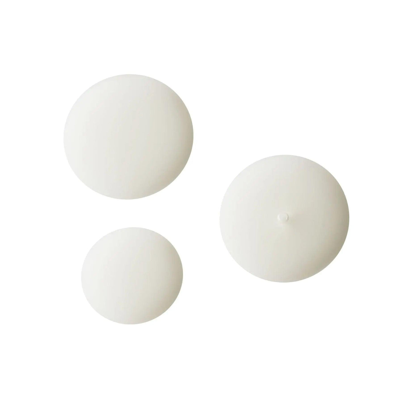 Three circular white cosmetic product containers for skincare, suitable for any beauty routine.