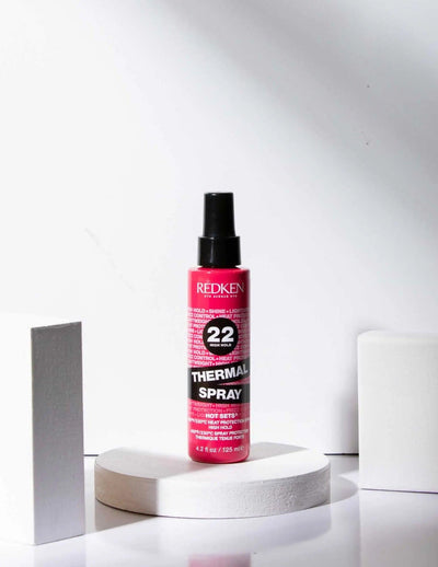 Redken Thermal Spray 22 High Hold thermal heat protection hairspray on display, ideal for all hair types and textures.