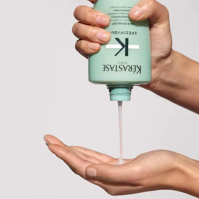 Applying Kerastase hair care product to hand for nourishing hair treatment