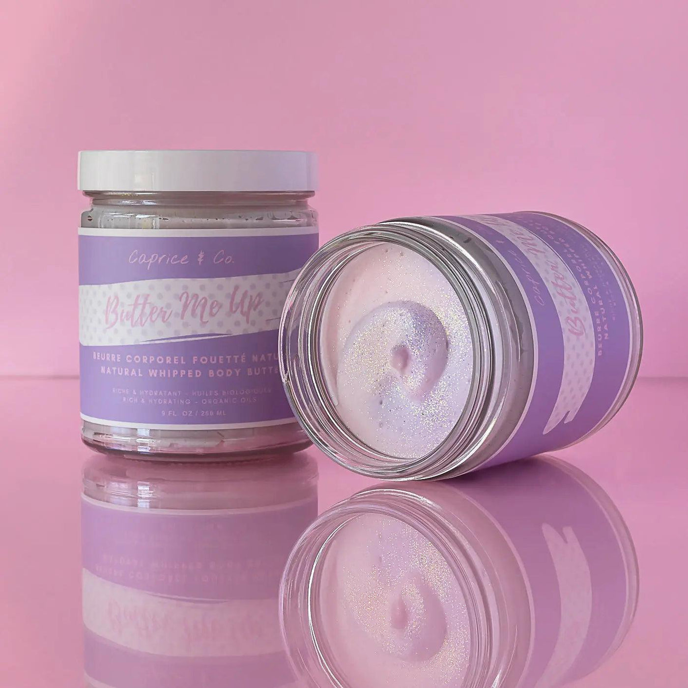 Natural extra whipped body butter in a glass jar, featuring juicy bubblegum scent and moisturizing ingredients on a pink background.