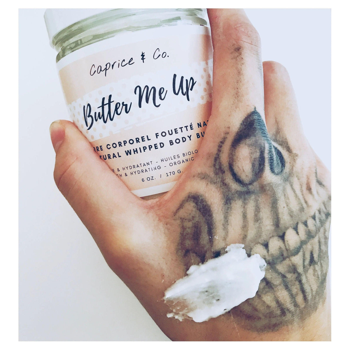 Natural whipped body butter in hand showing smooth application on skin, highlighting the 'Butter Me Up' product.