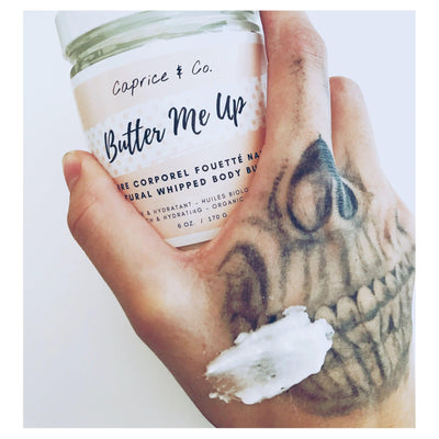 Natural whipped body butter in hand showing smooth application on skin, highlighting the 'Butter Me Up' product.