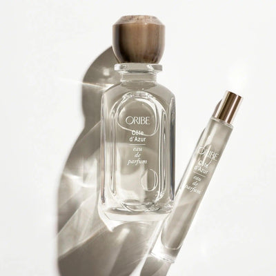 Elegant Côte d'Azur Eau De Parfum bottle and travel size spray on a reflective surface.