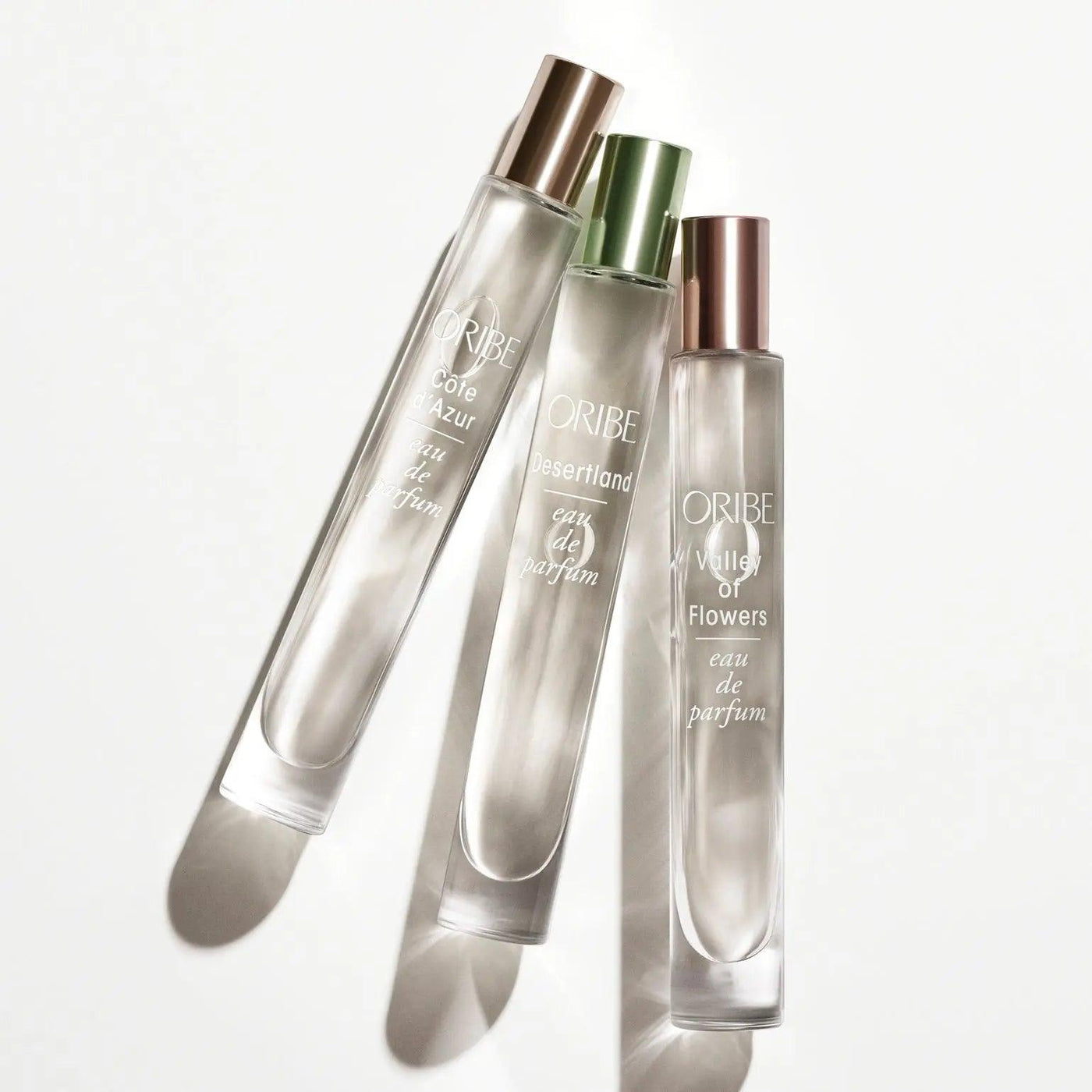 Three Oribe Eau de Parfum bottles including Côte d’Azur, Les Sables d’Or, and Village of Flowers.