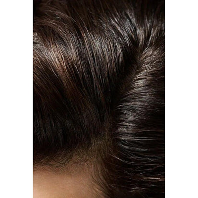 Close-up of shiny, healthy black hair with parting line.