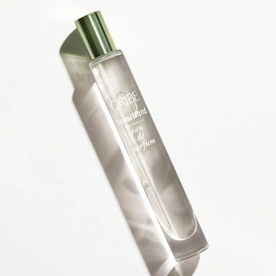 Oribe Desertland Eau De Parfum bottle showcasing elegant design with green cap and reflective surface.