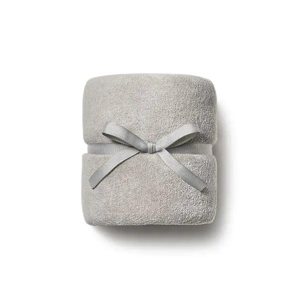 Soft gray DevaTowel wrapped with a ribbon, designed to enhance curl definition while reducing frizz. Size: 39" x 20".