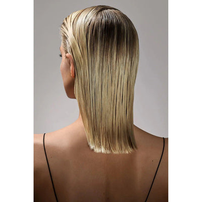Woman with sleek, wet-look, straight blonde hair photographed from the back, showcasing a smooth and shiny hairstyle.
