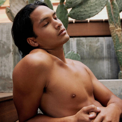 Relaxed man enjoying a calm moment outdoors, surrounded by cacti, showcasing smooth skin.