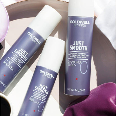 Goldwell Just Smooth hair care products, including Sleek Perfection and Diamond Gloss, arranged on a stylish background.