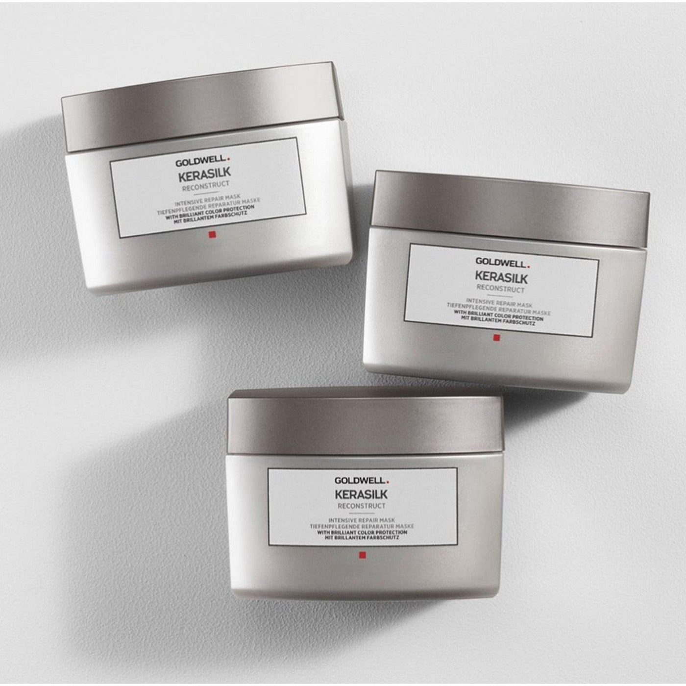 Three Goldwell Kerasilk Reconstruct Intensive Repair Mask jars arranged side by side for hair restoration and moisture.