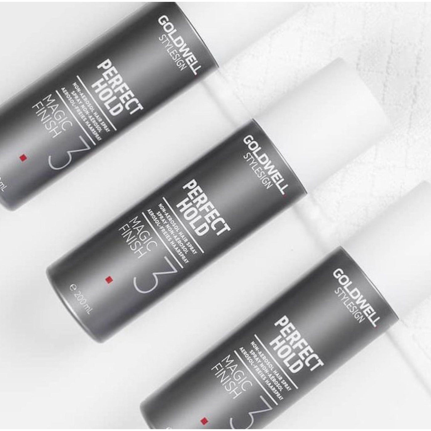 Three Goldwell Perfect Hold Magic Finish Hairspray bottles showcasing light to medium hold and shine.