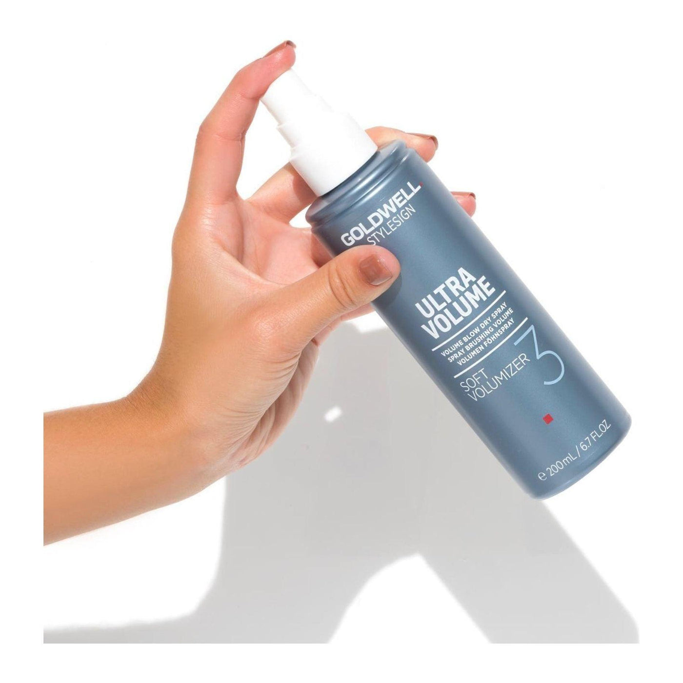 Goldwell Stylesign Ultra Volume Soft Volumizer Blow-Dry Spray held in hand for fine to normal hair styling.