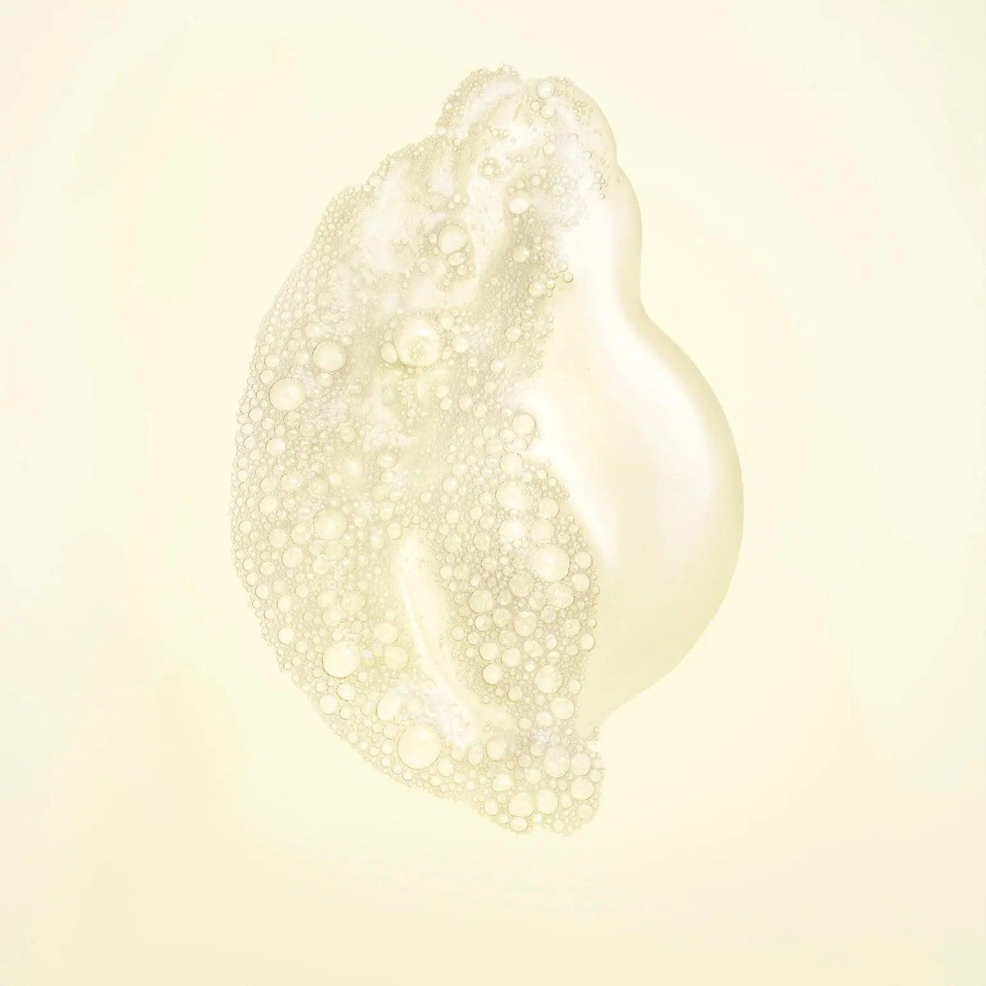 Nourishing shampoo bubble texture showcasing a creamy, foamy cleanser for strengthening hair.