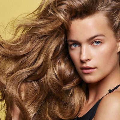 Model showcasing healthy, voluminous hair, emphasizing the benefits of Hair Alchemy Resilience Shampoo.