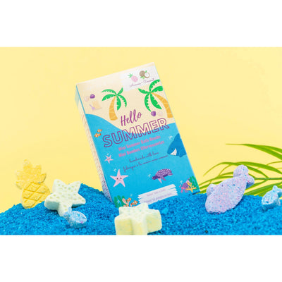 Hello Summer mini bath bombs packaging on blue sand with tropical decorations and vibrant colors, featuring pineapple and sea creatures.